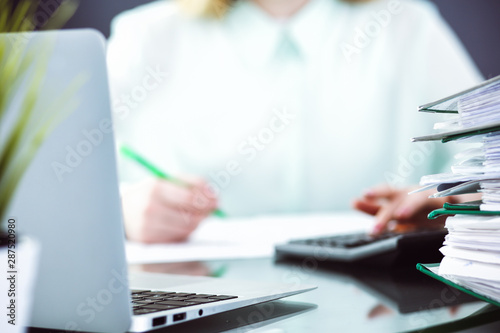 Bookkeeper or financial inspector making report, calculating or checking balance. Audit and tax service concept. Green colored image background