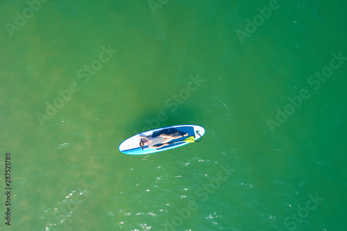 Summer Vacations. Beautiful Young Woman Relaxing on the SUP at Turquoise Water. Beauty, Wellness. Recreation.