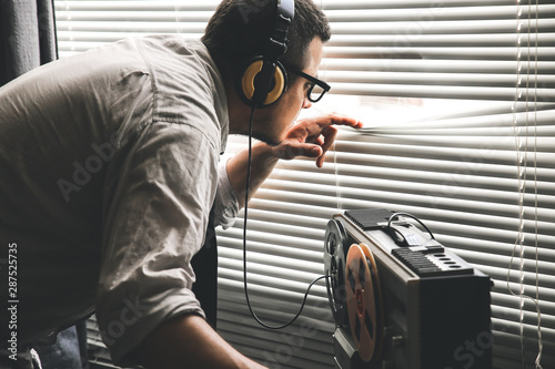 Obraz na plátně Special agent listens on the reel tape recorder