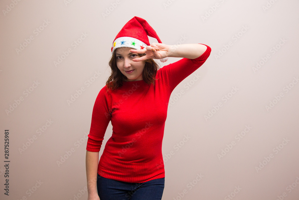 happy girl in santa hat in red blouse on white background 