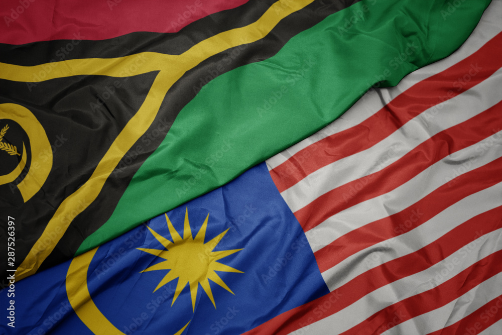 waving colorful flag of malaysia and national flag of Vanuatu .