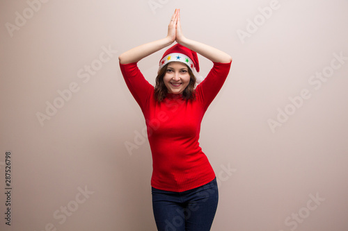 happy girl in santa hat in red blouse on white background  © Julia