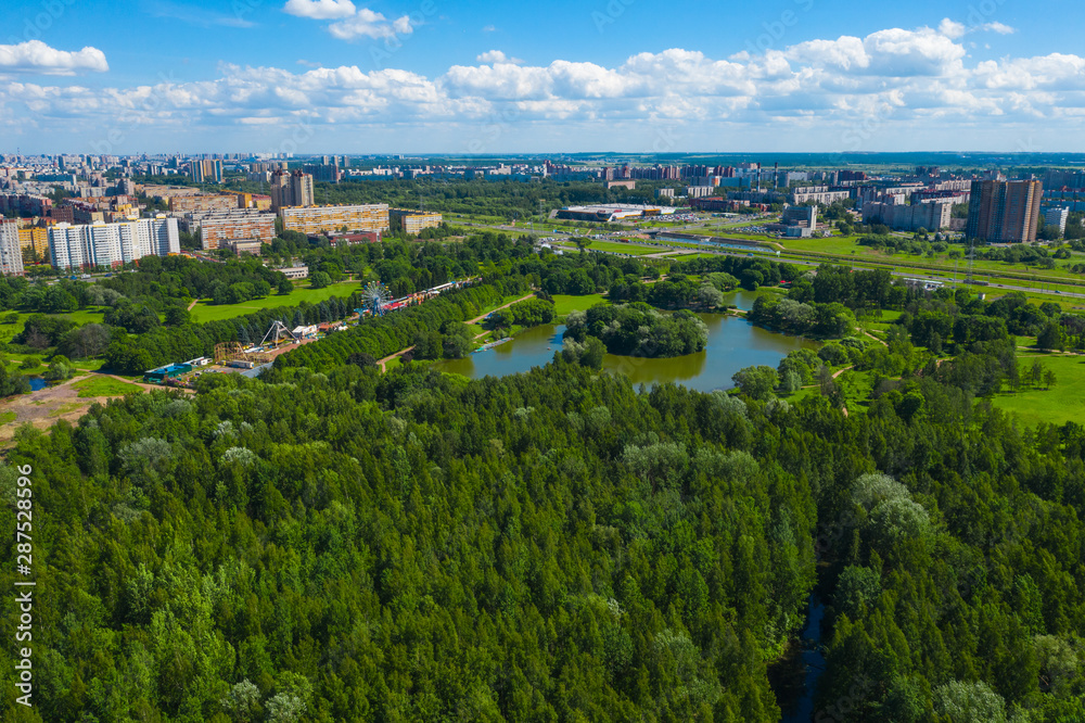 Aerial view of South Seaside Park on southwest part of St. Petersburg city. Summer, a lot of green trees, lake, blue sky. Russia