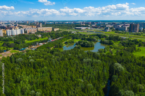 Aerial view of South Seaside Park on southwest part of St. Petersburg city. Summer, a lot of green trees, lake, blue sky. Russia