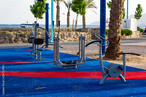 urban square district training apparatus  for sport activities on waterfront shoreline near sea with palm trees background