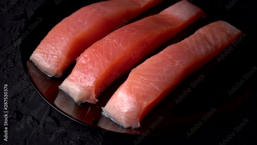 SalmoRaw salmon fillet on a slate board. Raw salmon red fish. HD, Slow motion, Cooking salmon, seafood. Healthy food concept.n SalmoRaw salmon fillet on a slate board. Raw salmon red fish. HD, Slow motion, Cooking salmon, seafood. Healthy food concept.n