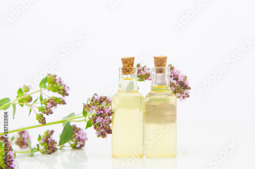 Essence of Oregano flowers on table in beautiful glass Bottle