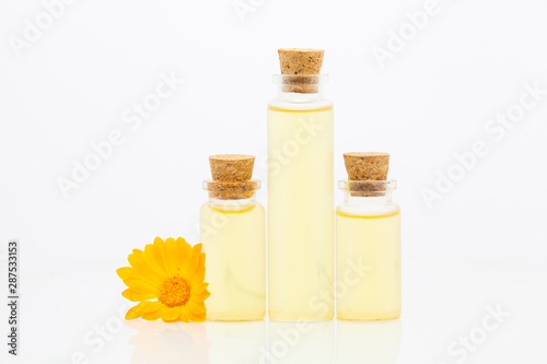 Essence of flowers on White background in beautiful glass bottle