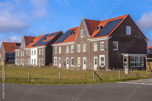 Fototapeta Naklejka Na Ścianę i Meble -  Modern row houses with red roof tiles on sunny day