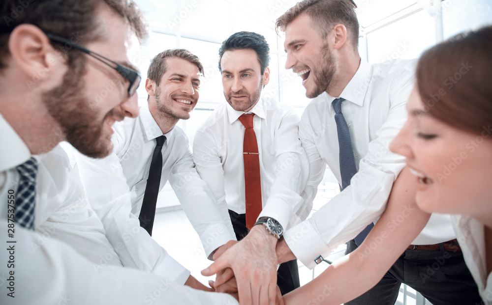 happy business team connects their hands together