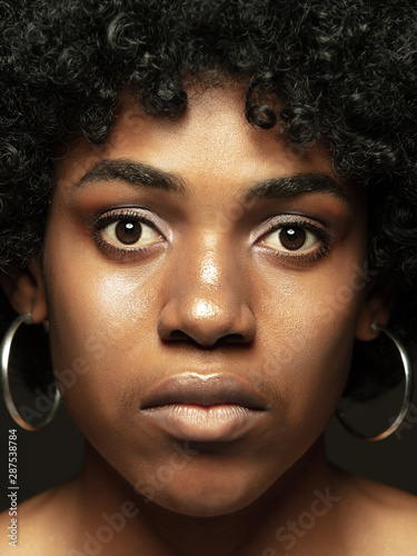 Close up portrait of young, emotional african-american woman. Highly detail photoshot of female model with well-kept skin and bright facial expression. Concept of human emotions. Calm, confident.
