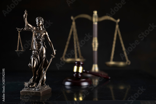 Law and justice theme. Gavel of the judge, Themis statue and the scale on the dark background.