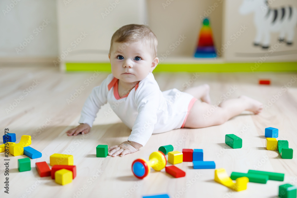 Cute baby girl playing with colorful rattle toys Cute baby girl playing with colorful rattle toys
