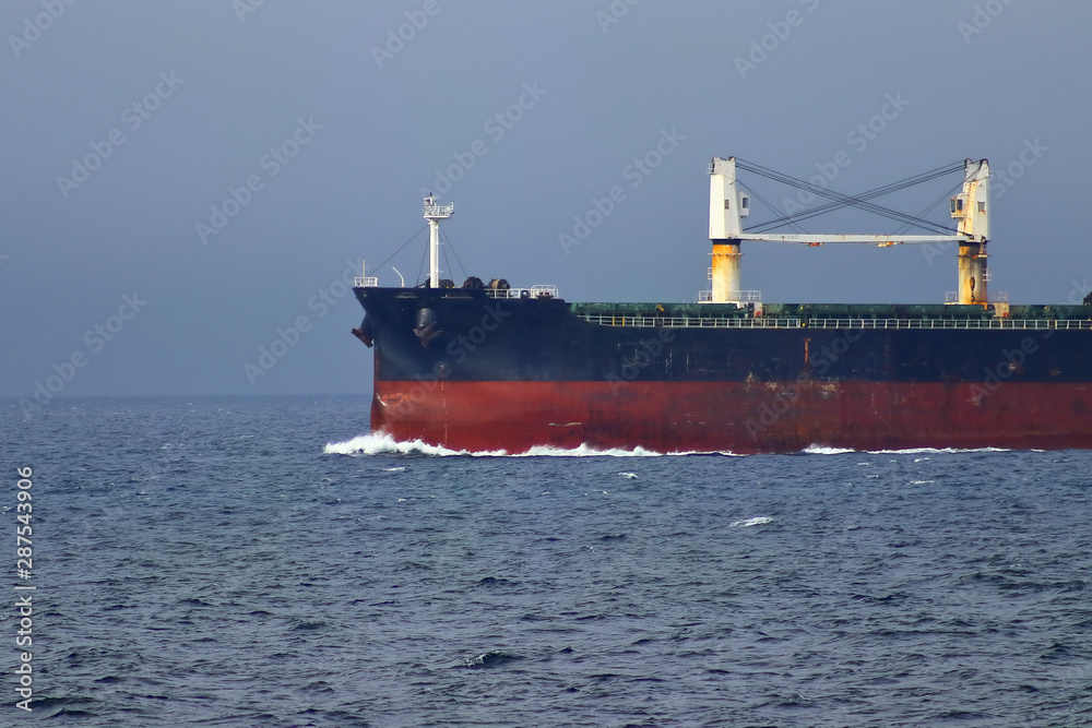 The bow of cargo ship cutting waves on full speed ahead.