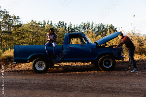 Young couple with their broken down pick-up truck