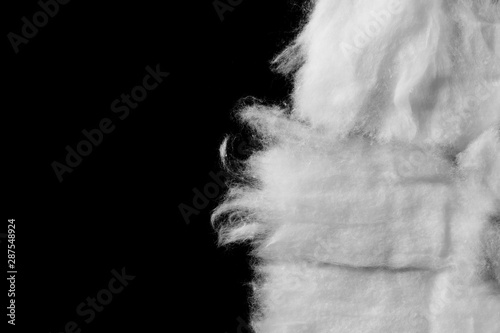 Wadding, absorbent cotton wool isolated on black background, top view
