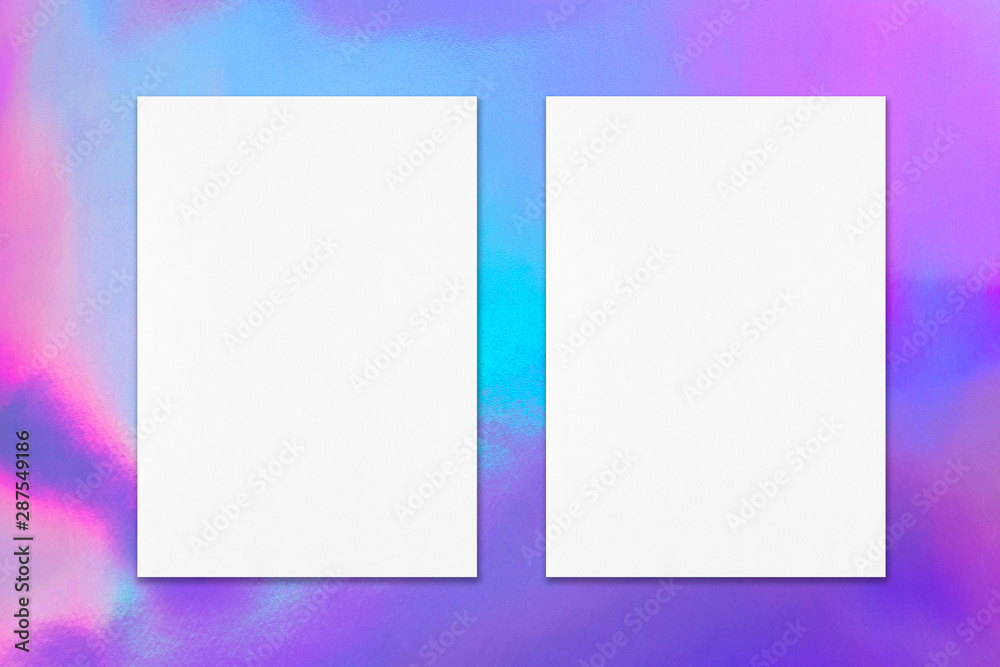 Two empty white vertical rectangle poster mockup with soft shadow on holographic background. Flat lay, top view Two empty white vertical rectangle poster mockup with soft shadow on holographic background. Flat lay, top view