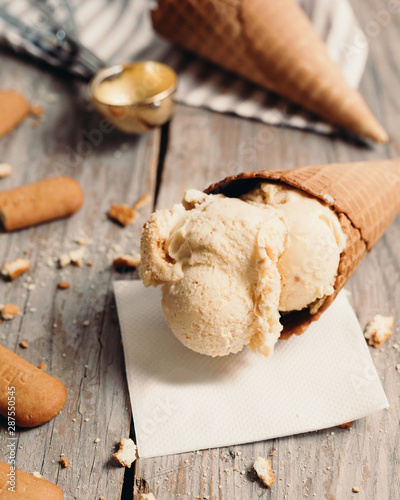 studio shot of tasty ice cream in cone on wooden table