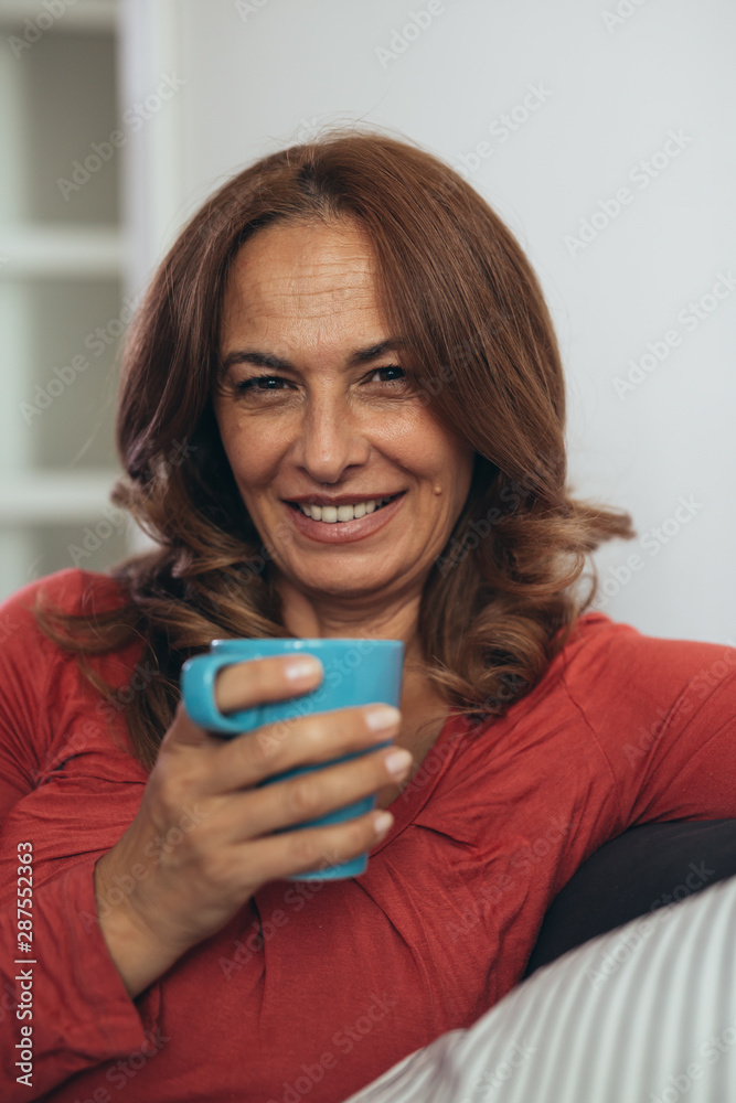 close up shot of mature woman holding cup of coffee or tea