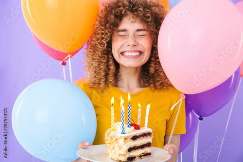 Photography Image of joyful young woman celebrating birthday with multicolored air balloons