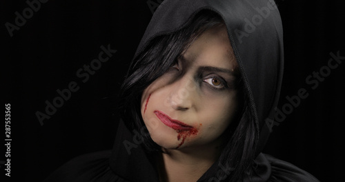 Vampire Halloween makeup. Woman portrait with blood on her face.