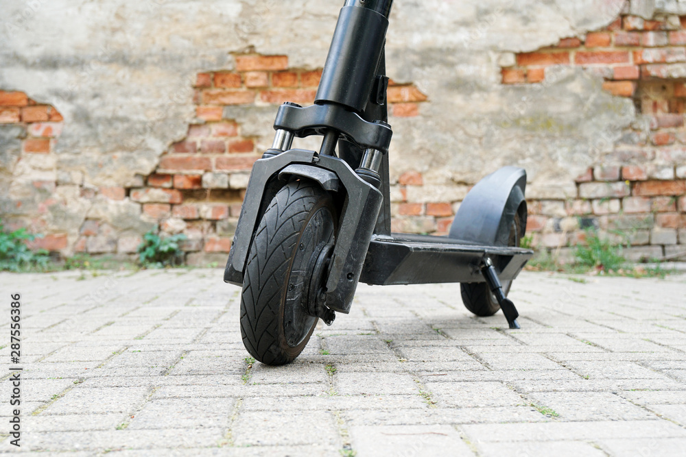 Electric kick scooter or e-scooter parked on pavement - e-mobility or micro-mobility  trend foto de Stock | Adobe Stock