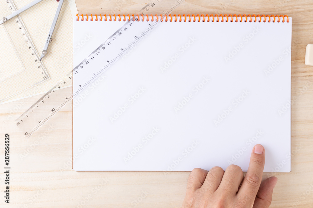left male hand pointing to an empty page of a spiral bound notebook left male hand pointing to an empty page of a spiral bound notebook