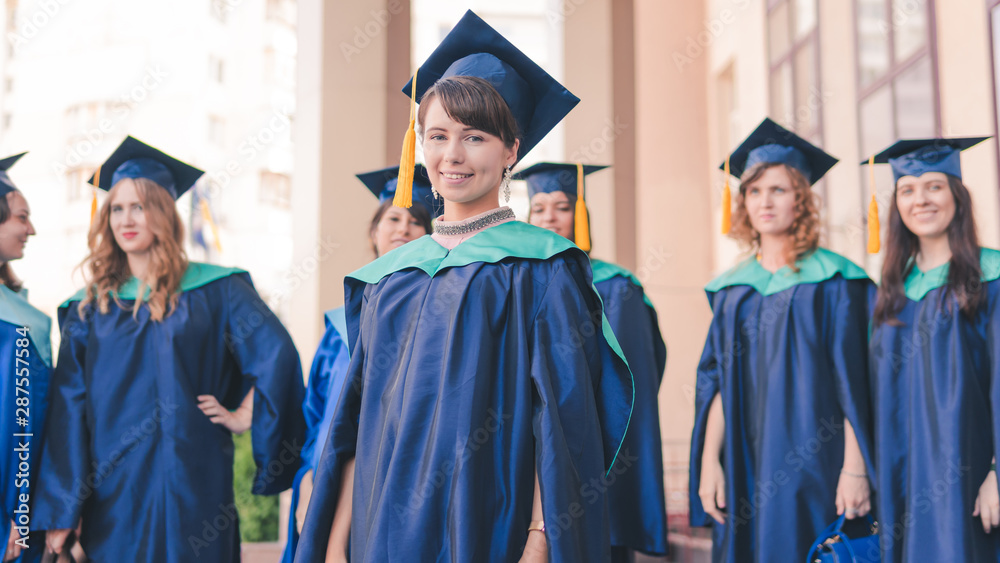 A group of young female graduates. Female graduate is smiling against the background of university graduates.