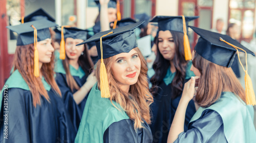 A group of young female graduates. Female graduate is smiling against the background of university graduates.