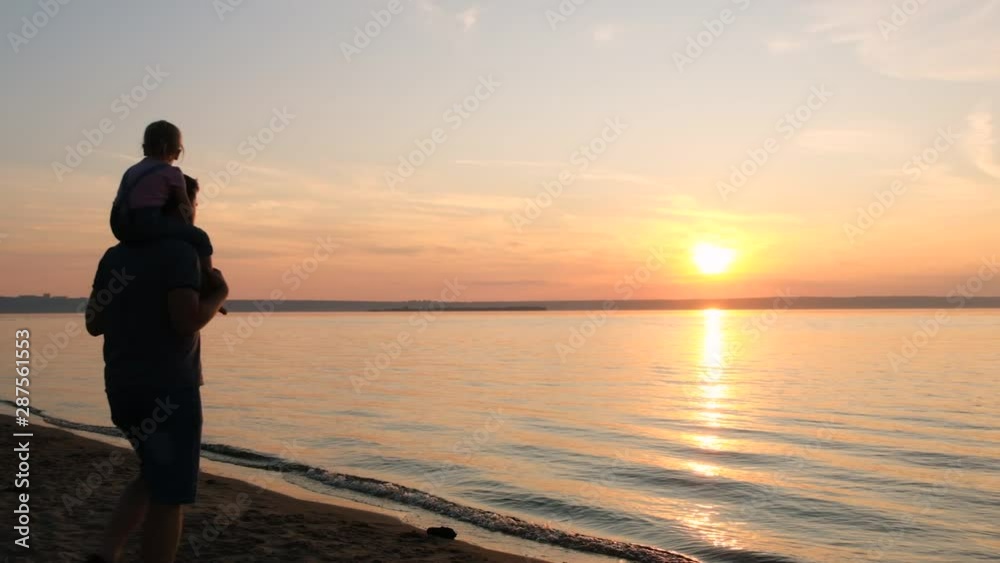 Silhouettes of happy father and daughter playing at sunset on the beach. Happy childhood, have fun. Slow motion. Silhouettes of happy father and daughter playing at sunset on the beach. Happy childhood, have fun. Slow motion.