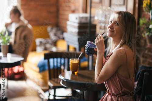 Fotografija beautiful pensive calm relaxed girl blonde sits at a table in a retro vintage st
