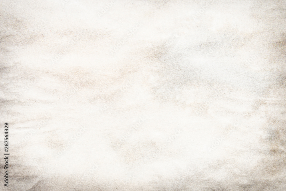 Fototapeta premium Old brown and white paper stained with coffee. Vintage abstract background.