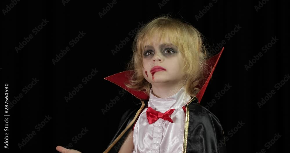 Dracula child. Girl with halloween make-up. Vampire kid with blood on her face Dracula child. Girl with halloween make-up. Vampire kid with blood on her face