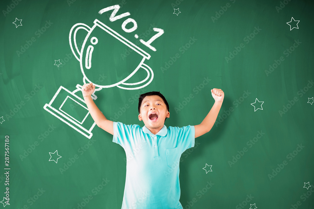happy little boy standing against chalkboard and showing the champions cup concepts