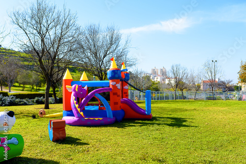Fototapeta Inflatable castle outdoor at sunny summer day.