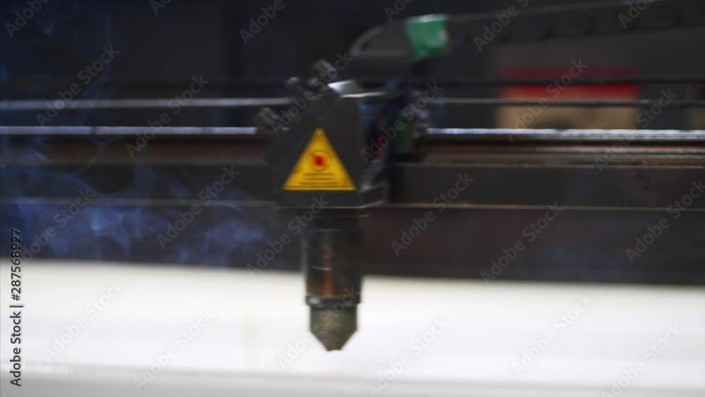 Industrial laser cutter is working and burning out at the factory and moving slowly with smoke Industrial laser cutter is working and burning out at the factory and moving slowly with smoke