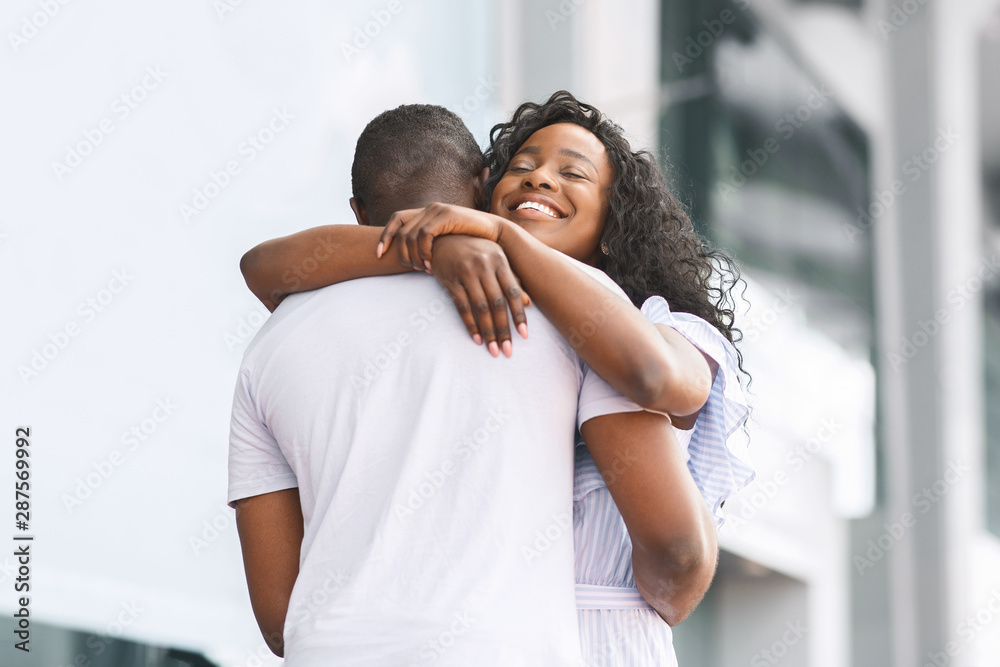 Happy african woman embracing her loving boyfriend