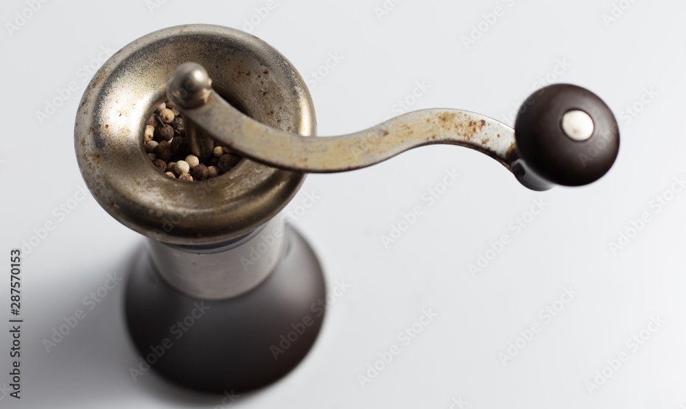 Close-up of ancient pepper mill on white background.