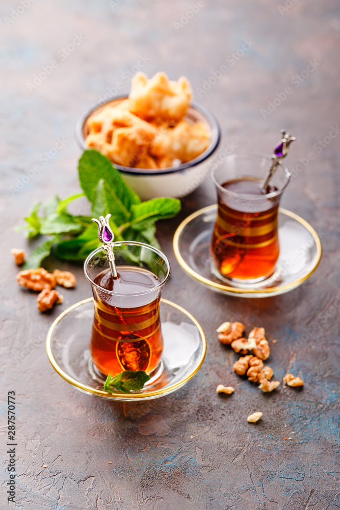 Traditional Turkish arabic dessert and a glass of tea with mint Traditional Turkish arabic dessert and a glass of tea with mint