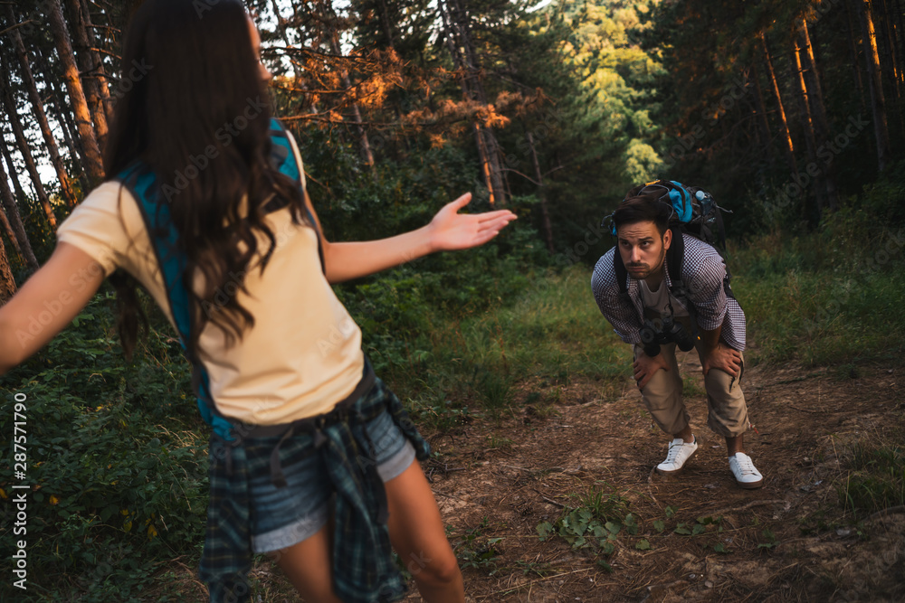 Fototapeta premium Young couple is hiking in forest. Man is tired.