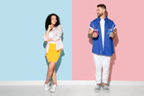 Young emotional caucasian couple in bright casual clothes posing on pink and blue background. Concept of human emotions, facial expession, relations, ad. Man and woman going to drink cocktails.