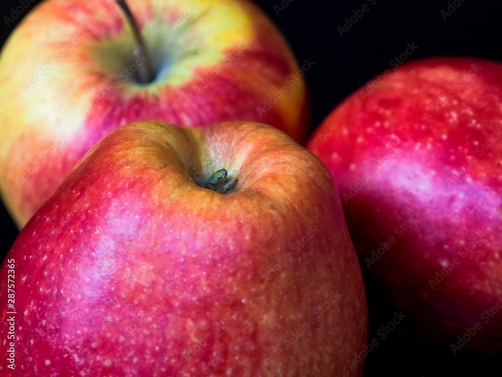 Three red apples on a black background, close-up, detail Three red apples on a black background, close-up, detail