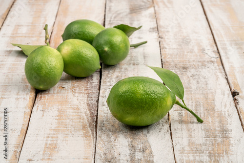 fresh green limes on a wooden table