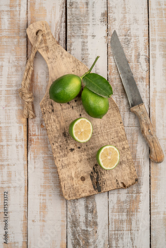 Fototapeta Naklejka Na Ścianę i Meble -  sliced limes on a wooden cutting board on a table