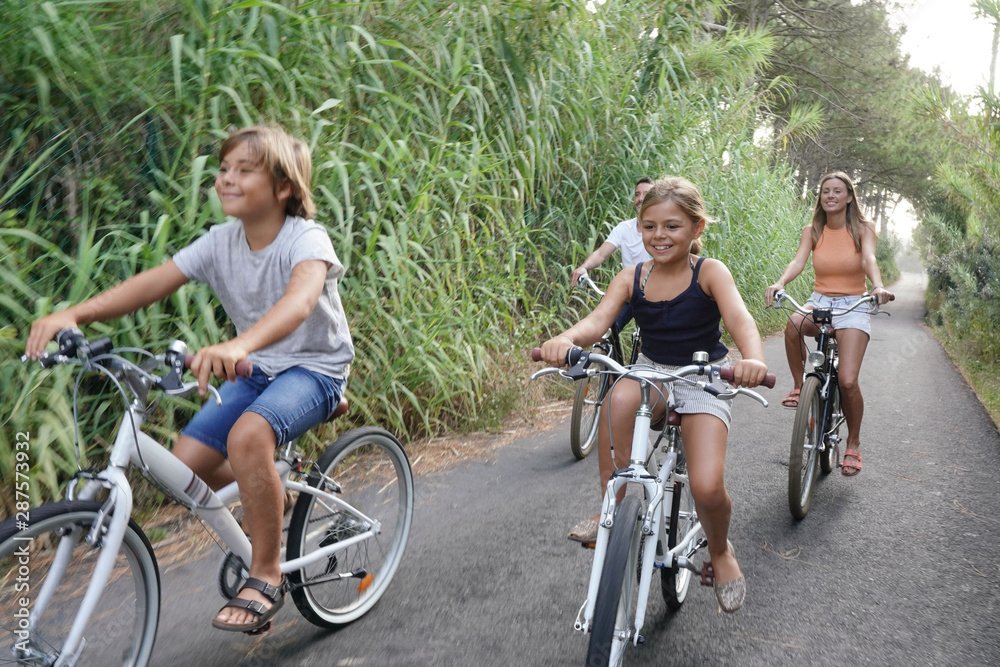 Happy family on vacation riding bikes