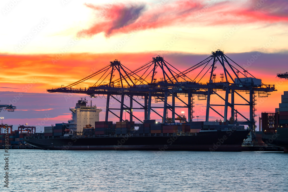 Obraz premium Cargo freight ship and cargo container working with crane at port area,Logistic Import Export at sunset,Thailand 4.0