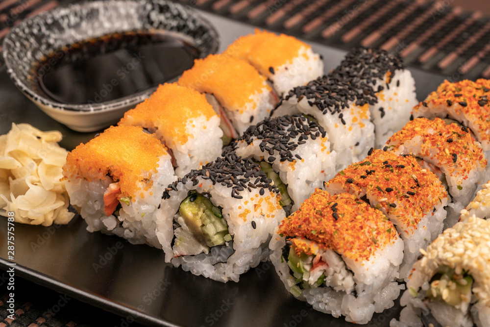 variety of sushi rolls served with soy sauce on table variety of sushi rolls served with soy sauce on table