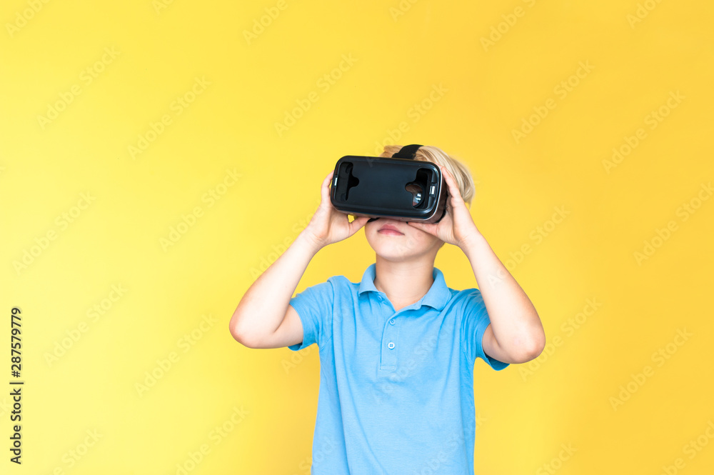 Little boy holds virtual reality hand 3D glasses on his head Little boy holds virtual reality hand 3D glasses on his head
