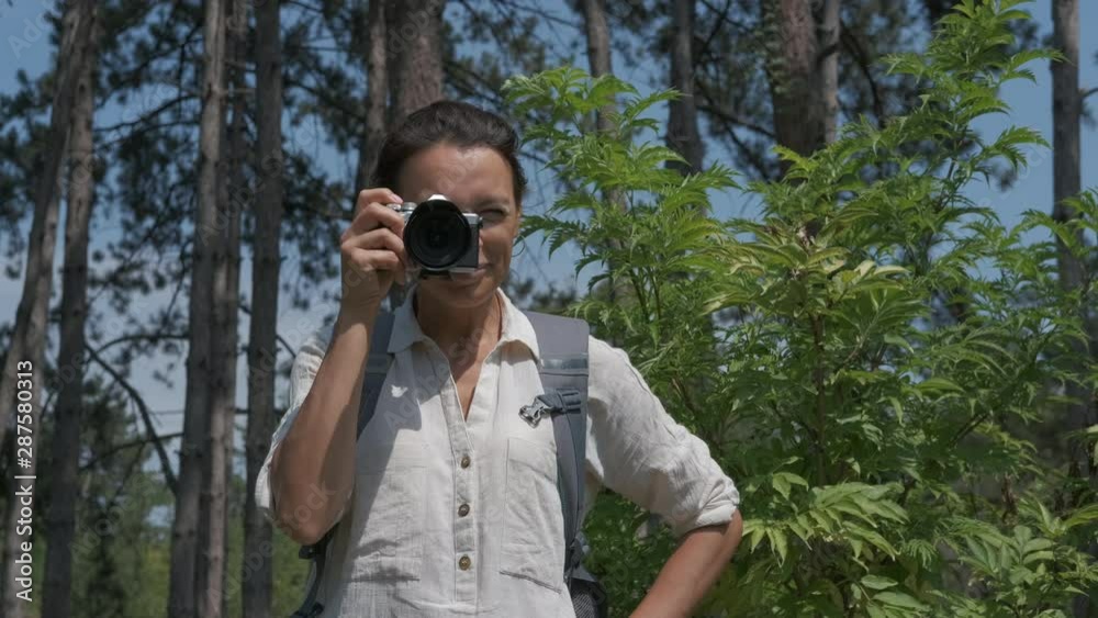 Happy woman photographer taking pictures in nature. Happy woman photographer taking pictures in nature.