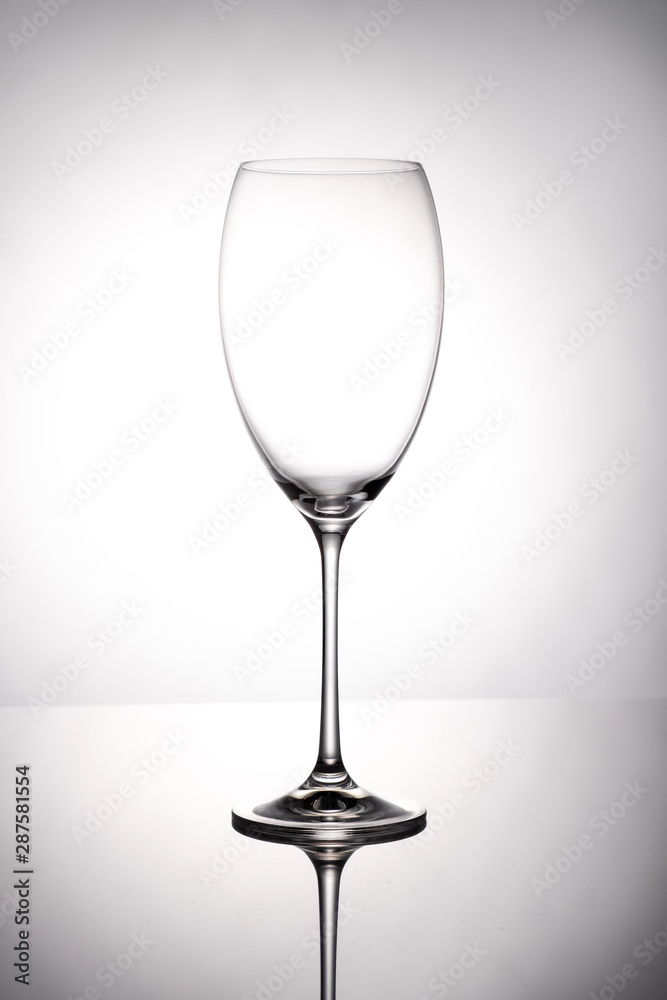 Empty wine glass goblets stands on a mirror surface on white background Empty wine glass goblets stands on a mirror surface on white background
